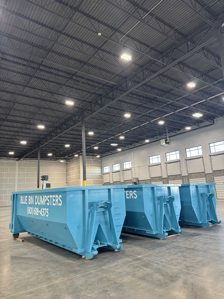 Blue Bin Dumpsters commercial roll-off containers staged inside a Salt Lake City warehouse
